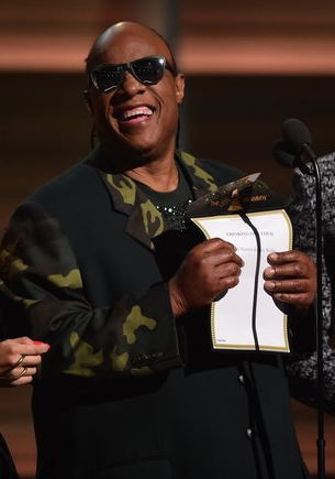 Stevie Wonder presenting 2016 Grammy award and reading from a braille card